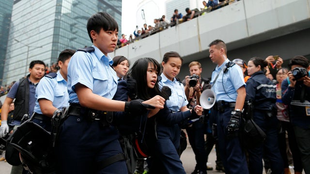 A demonstrator is taken away by police from an area previously blocked by pro-democracy protesters  