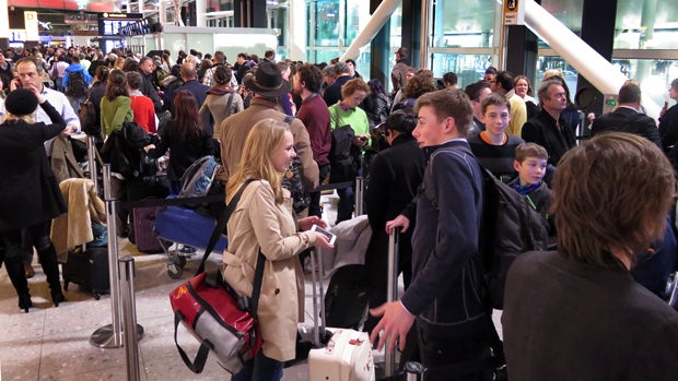 ​Passengers line up in Terminal Three as they wait for delayed flights at Heathrow Airport Dec. 12, 2014, in London. 