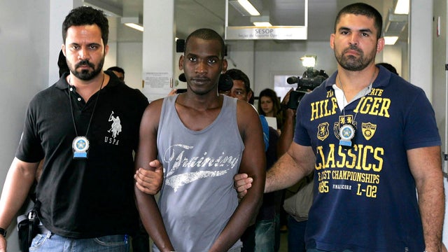Sailson Jose das Gracas, 26, is escorted by policemen at a police station in Nova Iguacu near Rio de Janeiro 