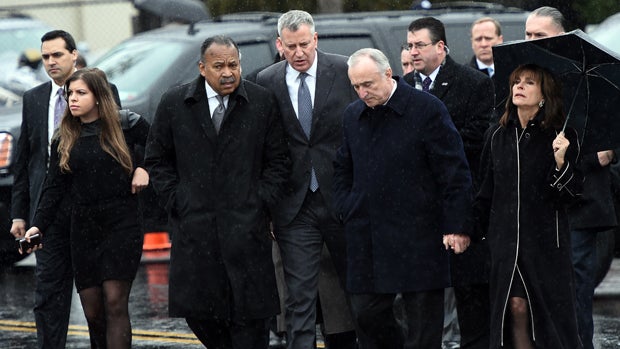 Police Commissioner Bill Bratton, center right, and New York Mayor Bill de Blasio, center, arrive to attend a wake for police officer Wenjian Liu at a funeral home in New York's borough of Brooklyn Jan. 3, 2015. 