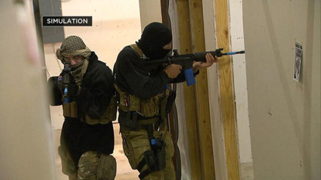 ​Masked gunmen carry out a simulation in Plano, Texas, Jan. 13, 2015, of the Paris shooting massacre. 