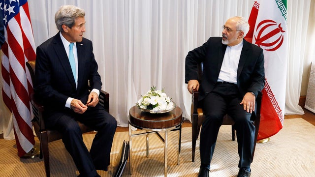 U.S. Secretary of State John Kerry sits with Iranian Foreign Minister Mohammad Javad Zarif  