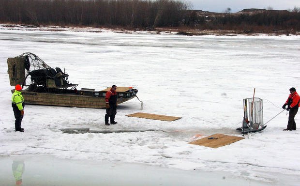 Cleanup workers cut holes into ice on Yellowstone River near Crane, Montana on January 19, 2015 as part of efforts to recover oil from upstream pipeline spill that released up to 50,000 gallons of crude oil 