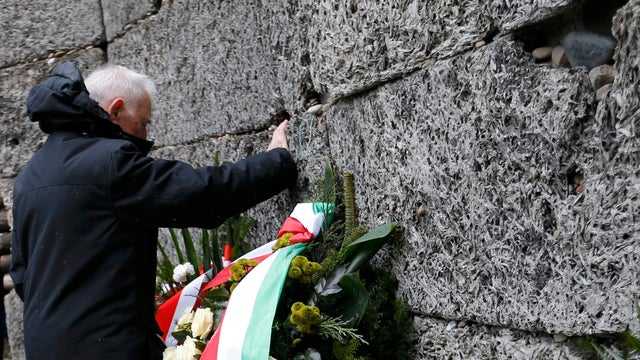 A survivor touches the "Wall of Death" in the former Nazi German concentration and extermination camp Auschwitz 