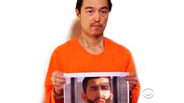 Image released Jan. 27, 2015, purportedly shows ISIS hostage Kenji Goto holding another image, of a Jordanian pilot also held captive by the group 