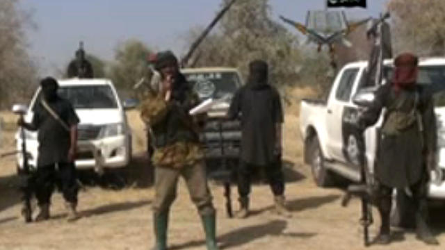 ​Boko Haram militants, and at center, the man claiming to be the group's leader, Abubakar Shekau, appear in a propaganda video 