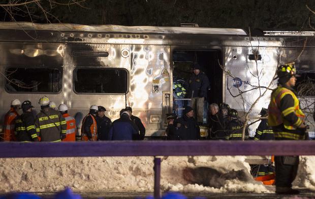Emergency workers stand in and around burned Metro-North Railroad commuter train in Valhalla, New York on February 3, 2015 