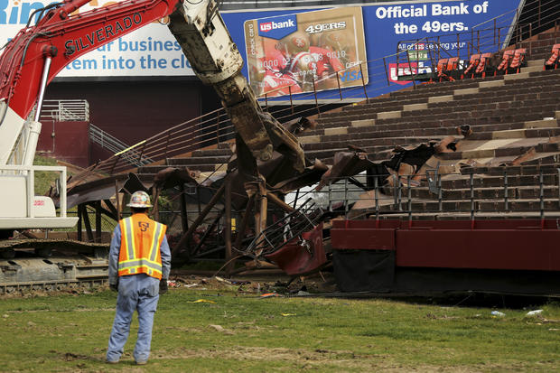 A worker watches as demolition equipment rips out a section of seating at Candlestick Park in San Francisco, California, Feb. 4, 2015. 