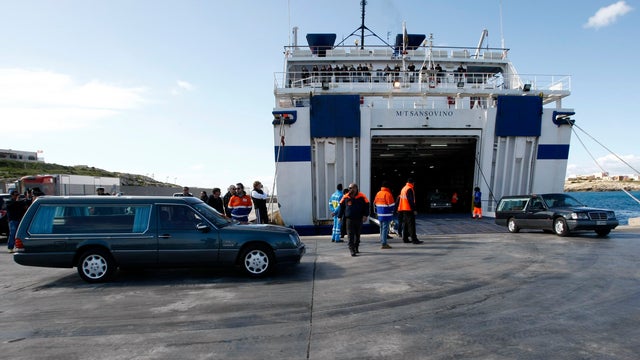 Hearses with the remains of migrants who died in a shipwreck arrive at the Lampedusa harbour Feb. 11, 2015.  
