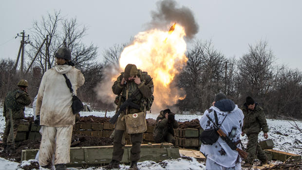 Russian-backed separatists cover their ears as they fire a mortar toward Ukrainian troops outside the village of Sanzharivka, northeast of Debaltseve, eastern Ukraine, Feb. 11, 2015. 