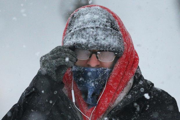 Pedestrian with his glasses fogged over walks through snow during winter blizzard in Cambridge, Massachusetts on February 15, 2015 