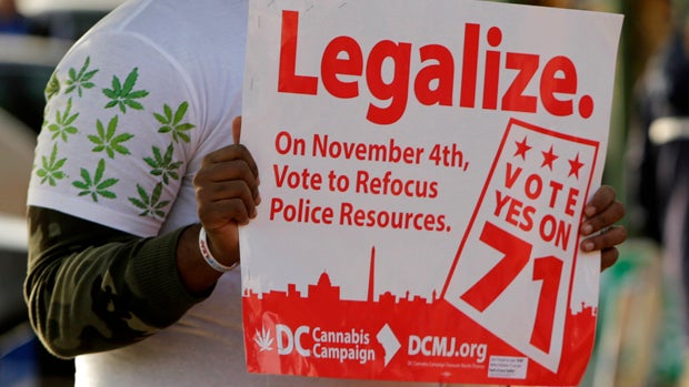 Melvin Clay of the DC Cannabis Campaign holds a sign urging voters to legalize marijuana at the Eastern Market polling station in Washington Nov. 4, 2014. 
