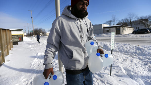 Lemott Thomas carries free water being distributed at the Lincoln Park United Methodist Church in Flint, Mich., Feb. 3, 2015. 