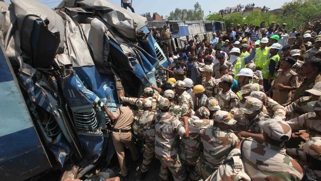 Rescue workers work to cut people free from mangled train carriages following the derailment of an express train at Bachrawan 