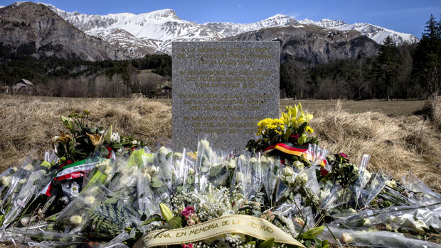 Flowers are pictured around a memorial, carved in French, German, Spanish and English, in memory of the victims of the Germanwings Airbus A320 crash in the small village of Le Vernet, French Alps, March 27, 2015, near the site where plane crashed March 24 