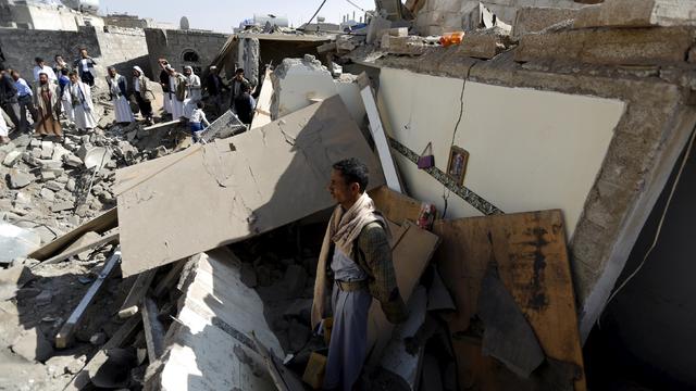 People gather near rubble of houses destroyed by an airstrike near Sanaa Airport 