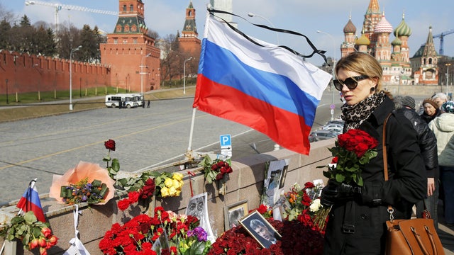 A woman holds flowers to commemorate Russian politician Boris Nemtsov at the site where he was killed, at the Great Moskvoretsky Bridge in central Moscow.  