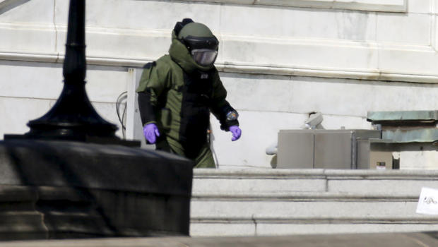 A police bomb squad officer inspects a suspicious package on the U.S. Capitol grounds after a shooting in Washington April 11, 2015. 