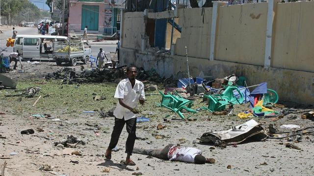 People run from the scene of a car bomb outside the Education Ministry in Mogadishu 