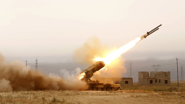 Iraqi pro-government forces, including fighters from the Shiite Muslim Al-Abbas popular mobilisation unit, fire a rocket during an clashes with ISIS around the Beiji oil refinery 