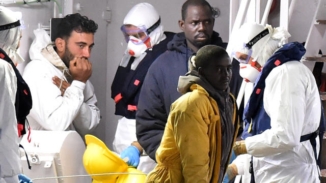 Migrants stand on the deck of the Italian Coast Guard ship Gregretti which is believed to be carrying 27 survivors of the migrant shipwreck in the Mediterranean, at Catania port 