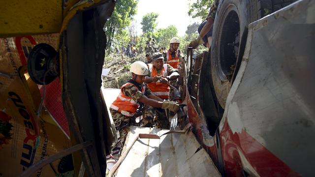 Rescue team members work to recover the bodies of victims from the wreckage of a bus at Jayaprekhola in Dhading district, on the outskirts of Kathmandu 