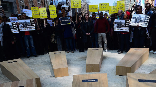 Amnesty International activists and migrants set up mock coffins while taking part in a "funeral march" to outline the Mediterranean migrant crisis around the European Council in Brussels 