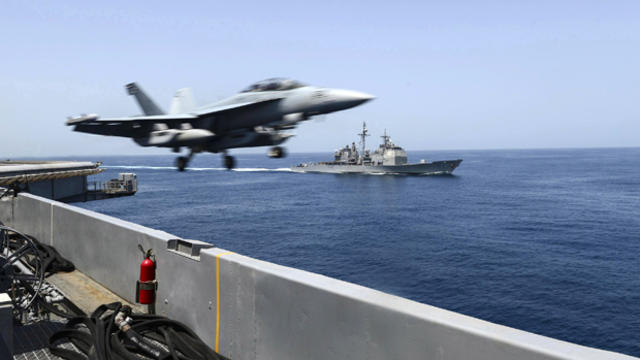 An EA-18G Growler launches from the flight deck of the aircraft carrier USS Theodore Roosevelt with the guided-missile cruiser USS Normandy alongside during maritime security operations in the Arabian Sea in this U.S. Navy photo taken April 21, 2015. 