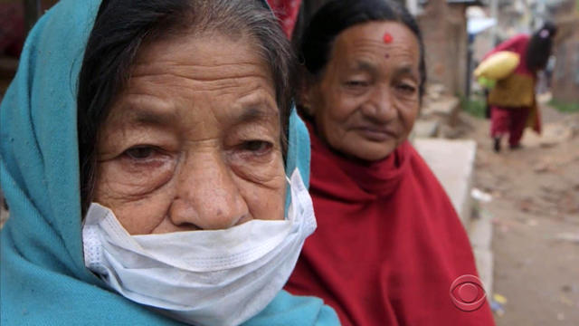 ​Two Nepalese women watch as rescuers search for a 9-year-old boy missing after the massive earthquake in Sankhu, Nepal, April 30, 2015. 