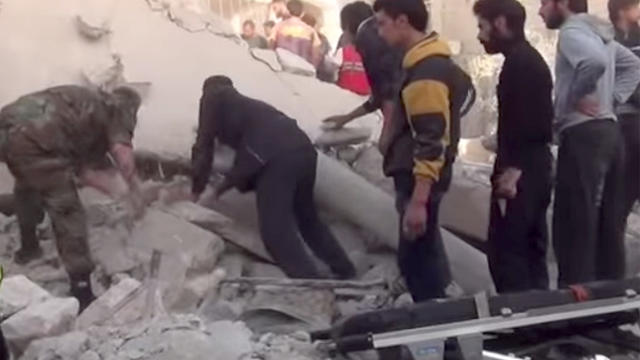 ​Residents and rescuers pick through the rubble of a building in Saraqeb, in Syria's Idlib province, allegedly destroyed by shelling from President Bashar Assad's military 