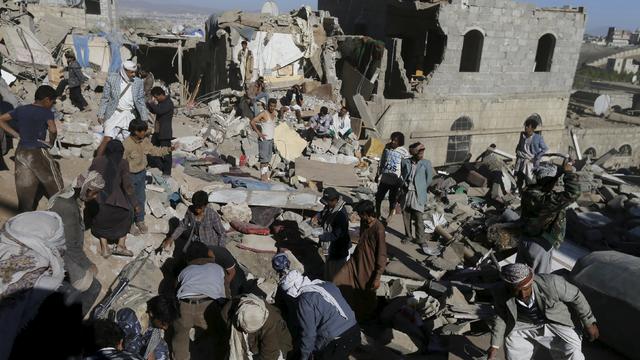 People clear rubble as they search for survivors after houses were destroyed by an overnight Saudi-led air strike on a residential area in Yemen's capital 