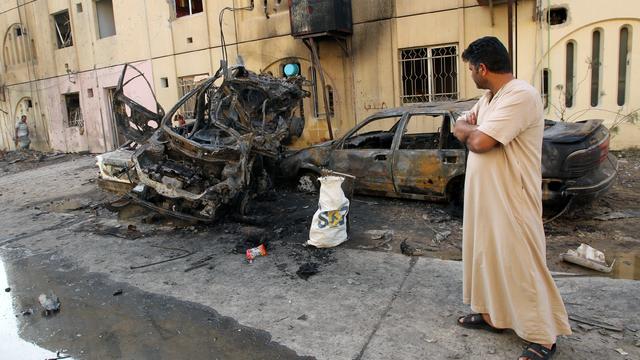 An Iraqi man looks at the wreckages of burnt cars, May 1, 2015, a day after a car bomb attack in the Baghdad neighbourhood of Talbiya 