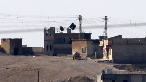 A black flag belonging to the Islamic State of Iraq and Syria is seen in the Syrian town of Kobani, as seen from the Turkish-Syrian border near the southeastern town of Suruc, Oct. 9, 2014. 