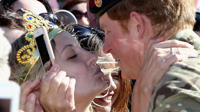 Prince Harry gets kissed by royal fan Victoria Mcrae during a walkabout outside the Sydney Opera House May 7, 2015, in Sydney, Australia. 