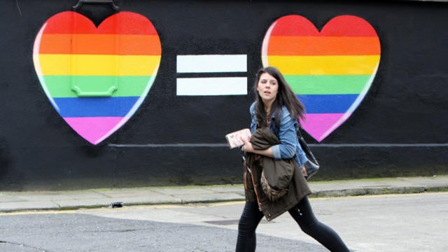 ​A woman walks past a mural in favor of same-sex marriage in Dublin May 21, 2015. 