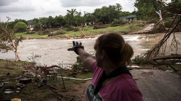 Amy Gilmour describes how the Blanco River crested at a record 43 feet during the Memorial Day weekend floods while helping pick up debris from the backyards of flood-damaged homes in Wimberley, Texas, May 26, 2015. 