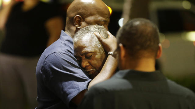 Worshippers embrace following group prayer across street from scene of shooting in historic black church on night of June 17, 2015, in Charleston, S.C. 