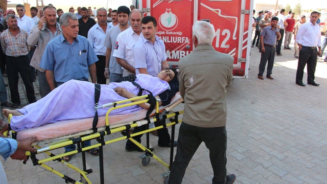 A wounded woman is wheeled by paramedics in Suruc in Turkey's Sanliurfa province across the Syrian border town of Kobani 
