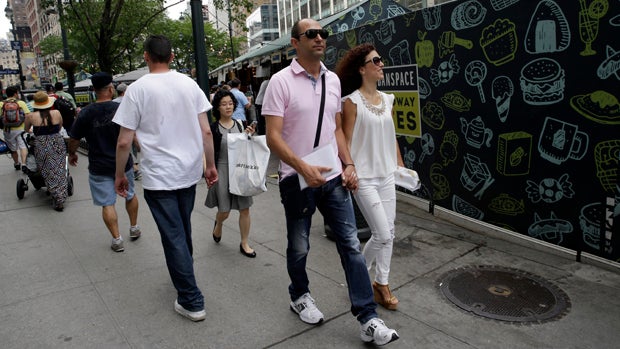 Newlyweds Valasia Limnioti, right, and Konstantinos Patronis walk in Midtown Manhattan July 2, 2015, in New York. 