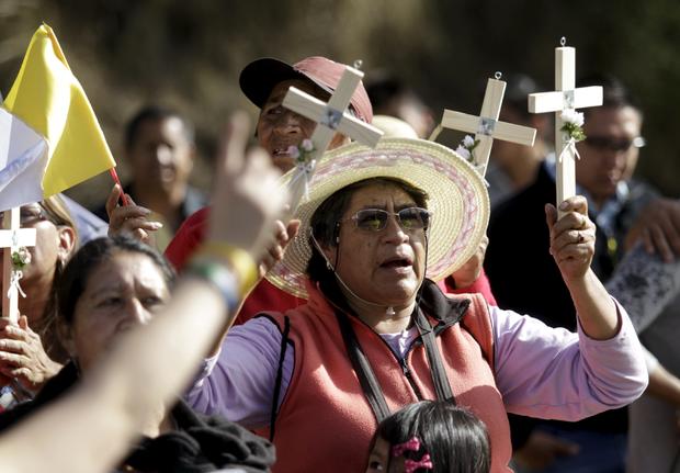 Catholic faithful wait for Pope Francis to drive past in Quito 