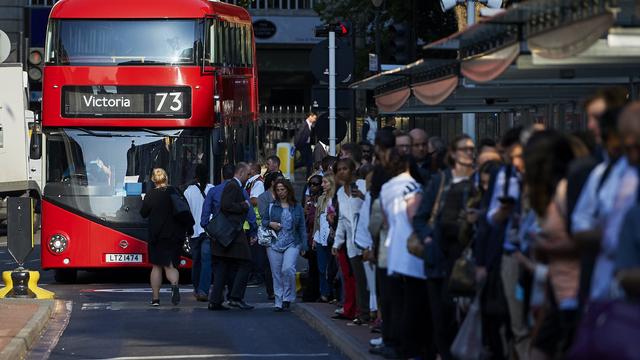 Early morning commuters form queues to board buses at Victoria station during a Tube strike in London 