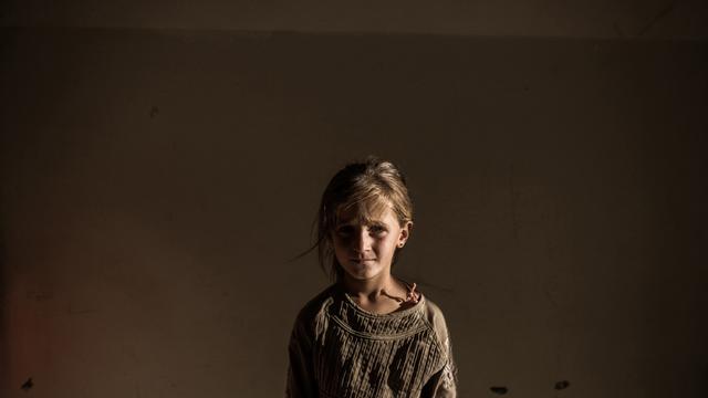 ​A Syrian refugee girl stands in a building in the Syrian Kurdish city of Amuda, after running away from clashes between regime forces and the Islamic State of Iraq and Syria (ISIS) 