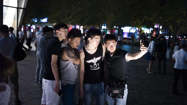 People gather for a selfie in front of a Uniqlo clothes store in Beijing 