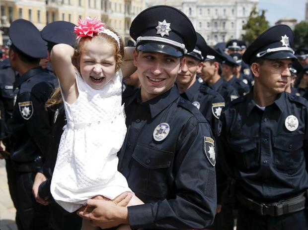 A police officer holds his daughter after an oath-taking ceremony, which started up the work of a new police patrol service, part of the Interior Ministry reform initiated by Ukrainian authorities, in Kiev, Ukraine 
