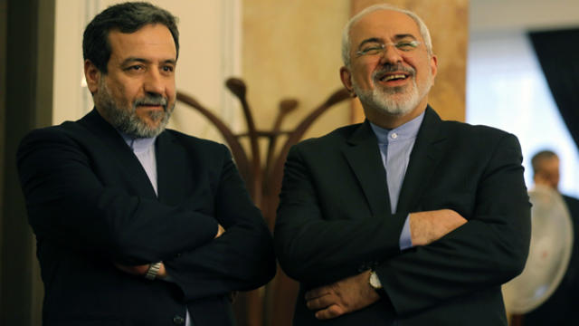 Iranian Foreign Minister Javad Zarif, right, and Deputy Foreign Minister Abbas Araghchi react as they listen to President Hassan Rouhani, unseen, speaking during a press conference in Tehran April 3, 2015. 