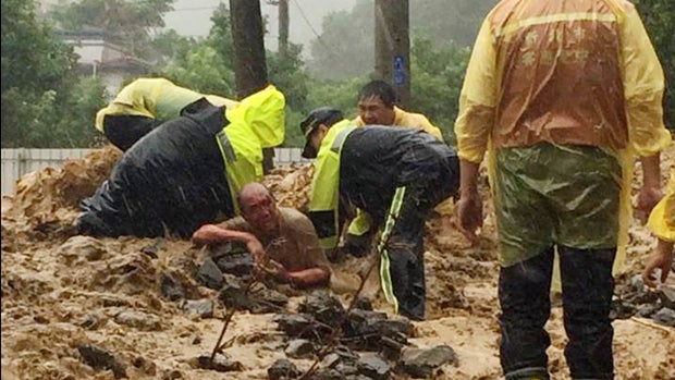 Emergency rescue personnel dig a man from a flash mudslide caused by Typhoon Soudelor in Xindian, New Taipei City, northern Taiwan, Aug. 8, 2015, in this image released by the New Taipei Fire Department. 
