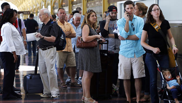 People stand in line at Washington's Reagan National Airport after technical issues at a Federal Aviation Administration center in Virginia caused delays Aug. 15, 2015. 
