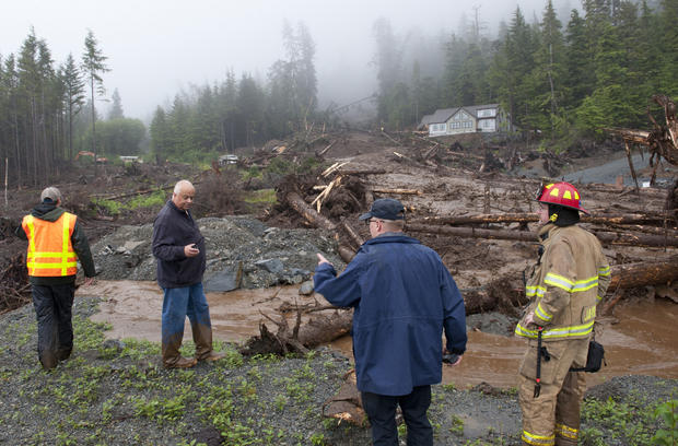 From left, city engineer Dan Tadic, Fire Chief Dave Miller, Search and Rescue Capt. Lance Ewers and firefighter Rob Janik look at the damage caused by a landslide Aug. 18, 2015, in Sitka, Alaska. 