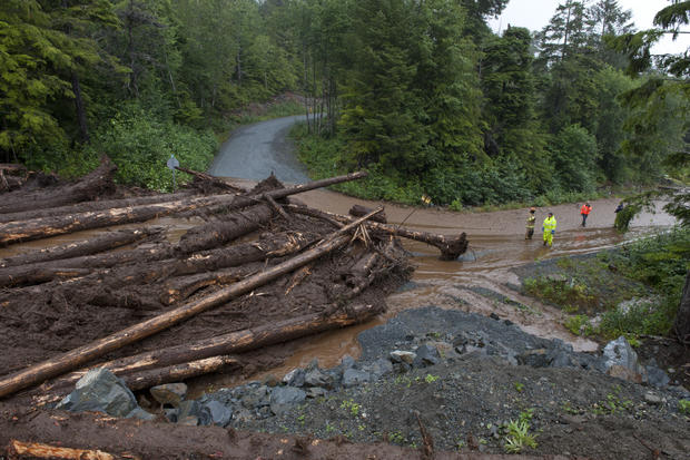 Construction workers and emergency crew members look at the damage caused by a landslide Aug. 18, 2015, in Sitka, Alaska. 