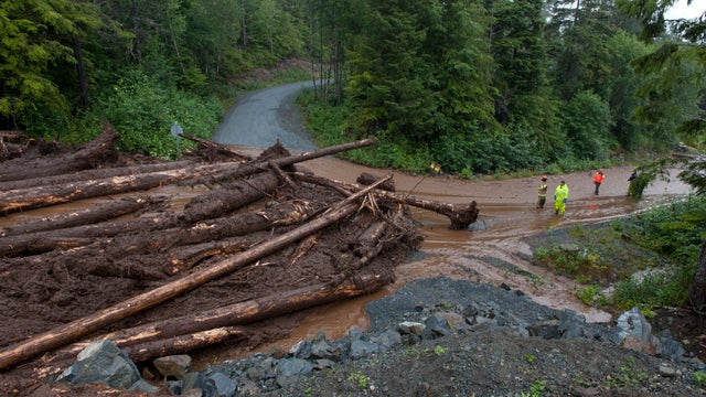 ​Construction workers and emergency crew members look at the damage caused by a landslide Aug. 18, 2015, in Sitka, Alaska. 